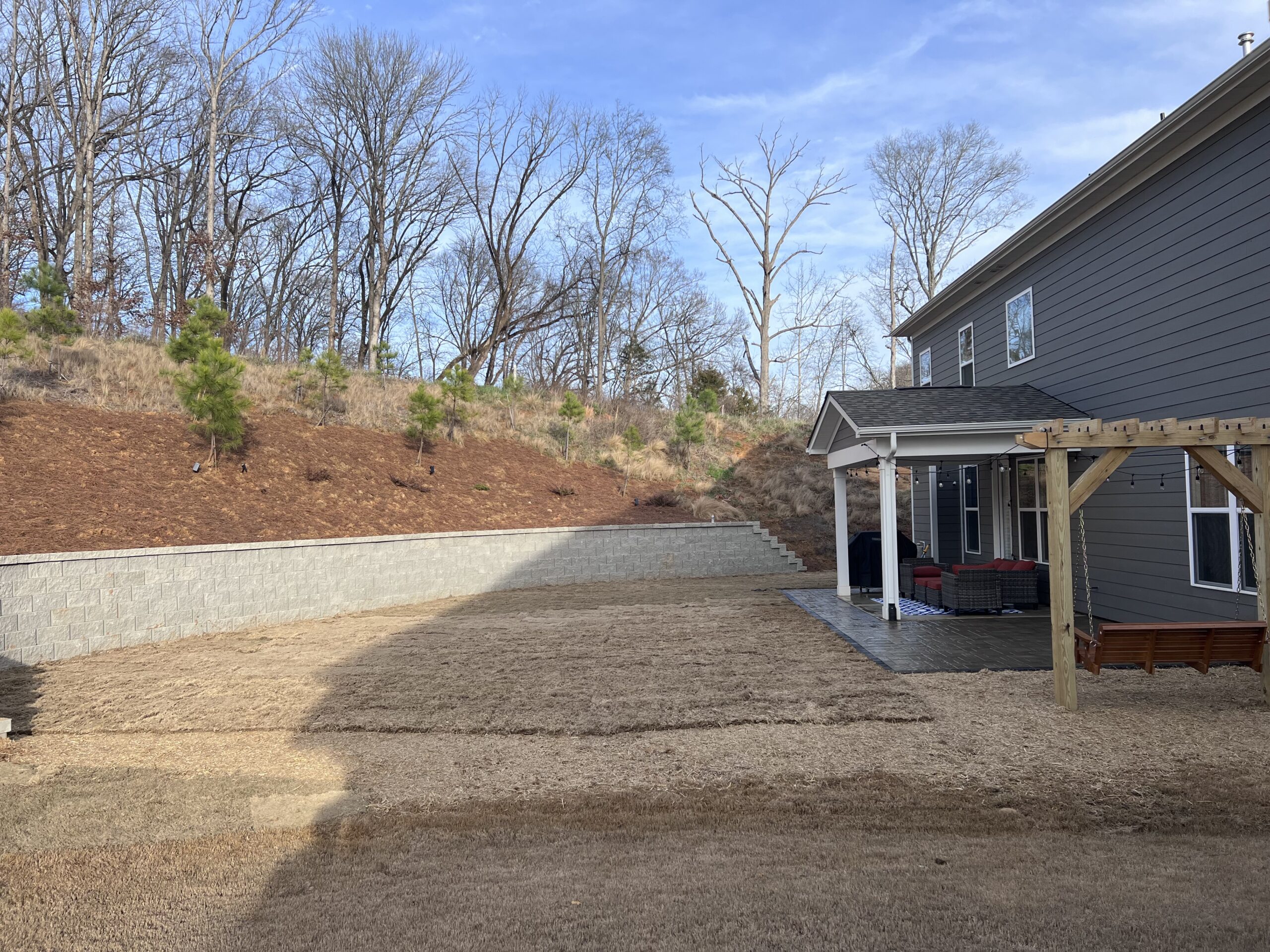 New patio and retaining wall behind a house.