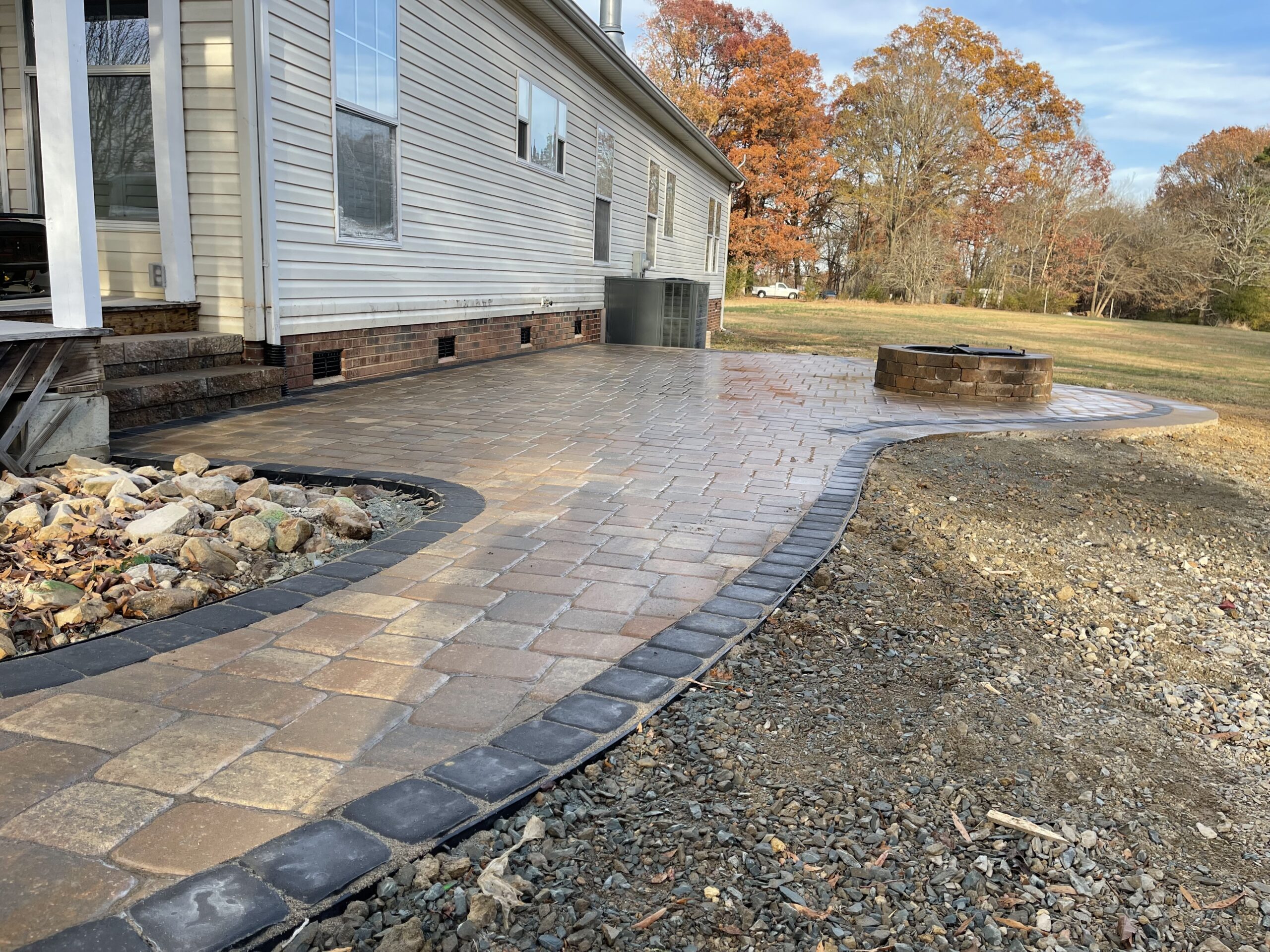 Patio with fire pit next to a house.