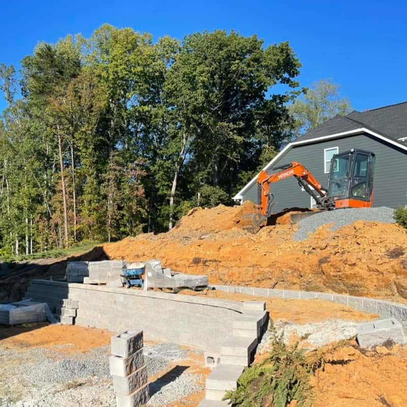 Various retaining wall styles, including block and tiered walls, designed for Charlotte, NC landscapes.